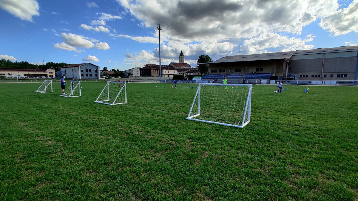 white metal frame on green grass field under blue sky during daytime