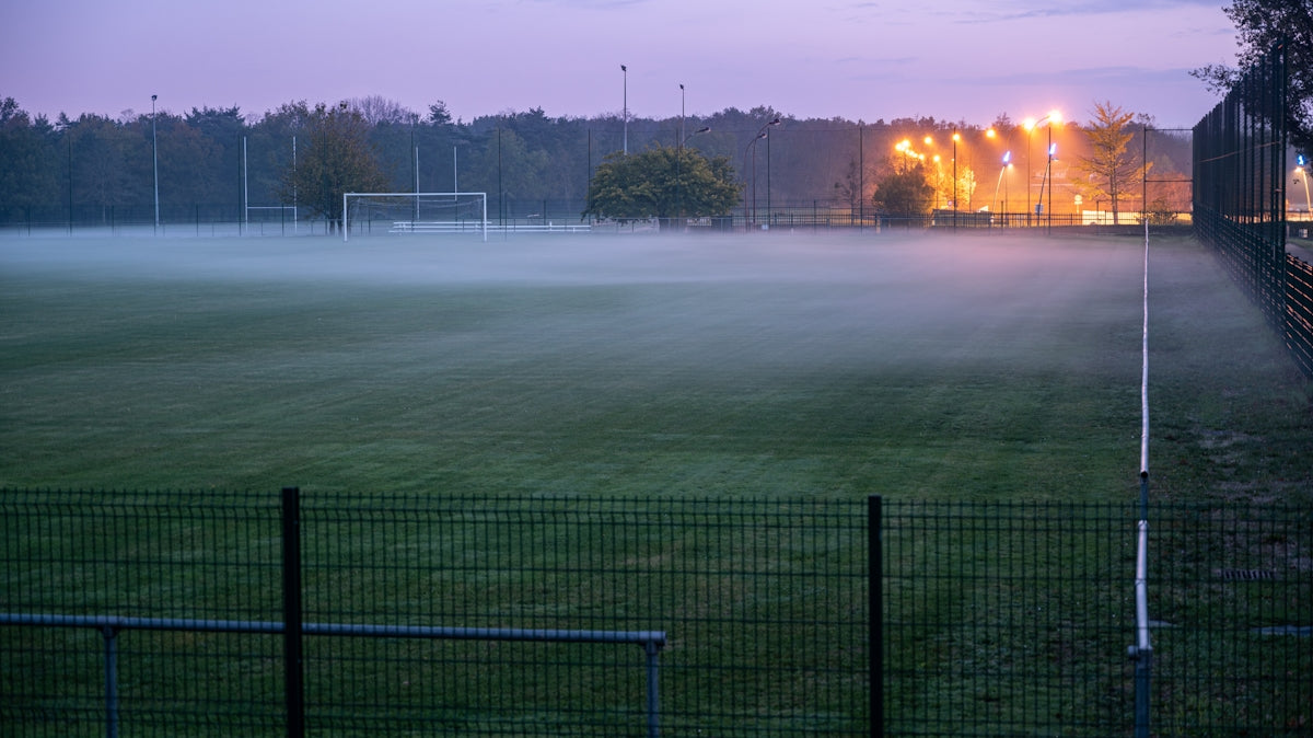 green grass field near green metal fence during daytime