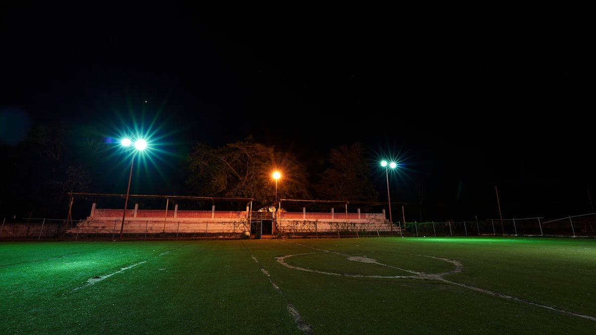 a soccer field at night with green lights
