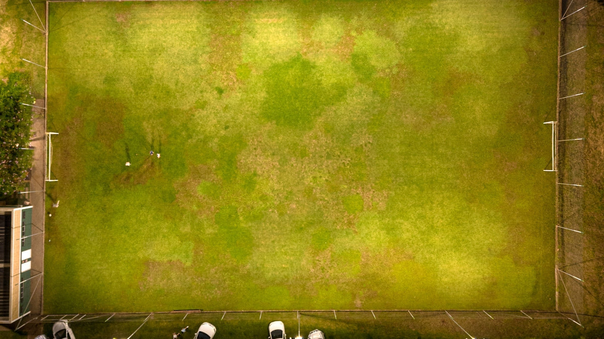 an overhead view of a soccer field with cars parked in it