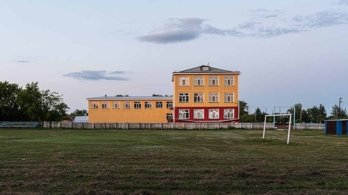 a soccer goal in front of a yellow building