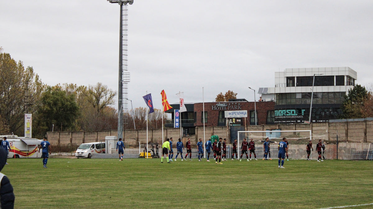 a group of people standing on top of a soccer field