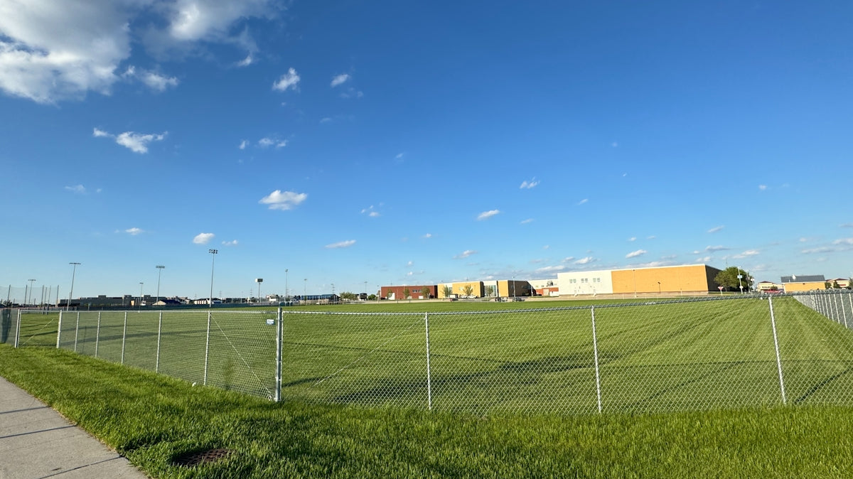 a grassy field with a building in the background
