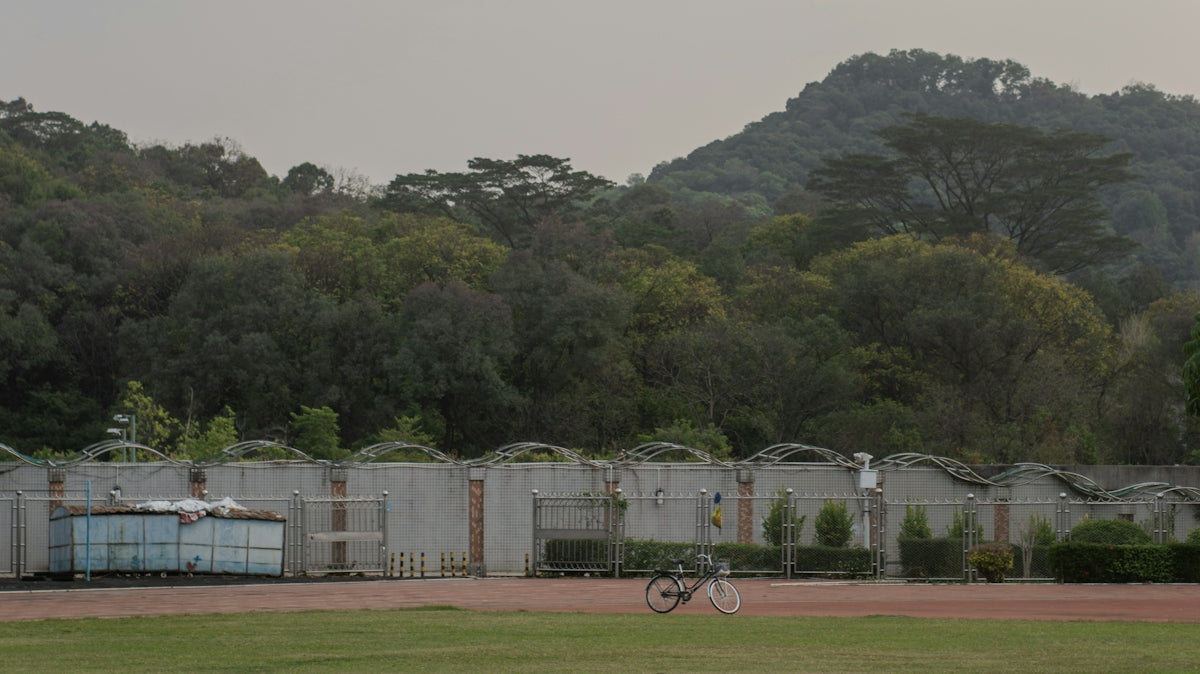 A bicycle on a track in front of green hills.