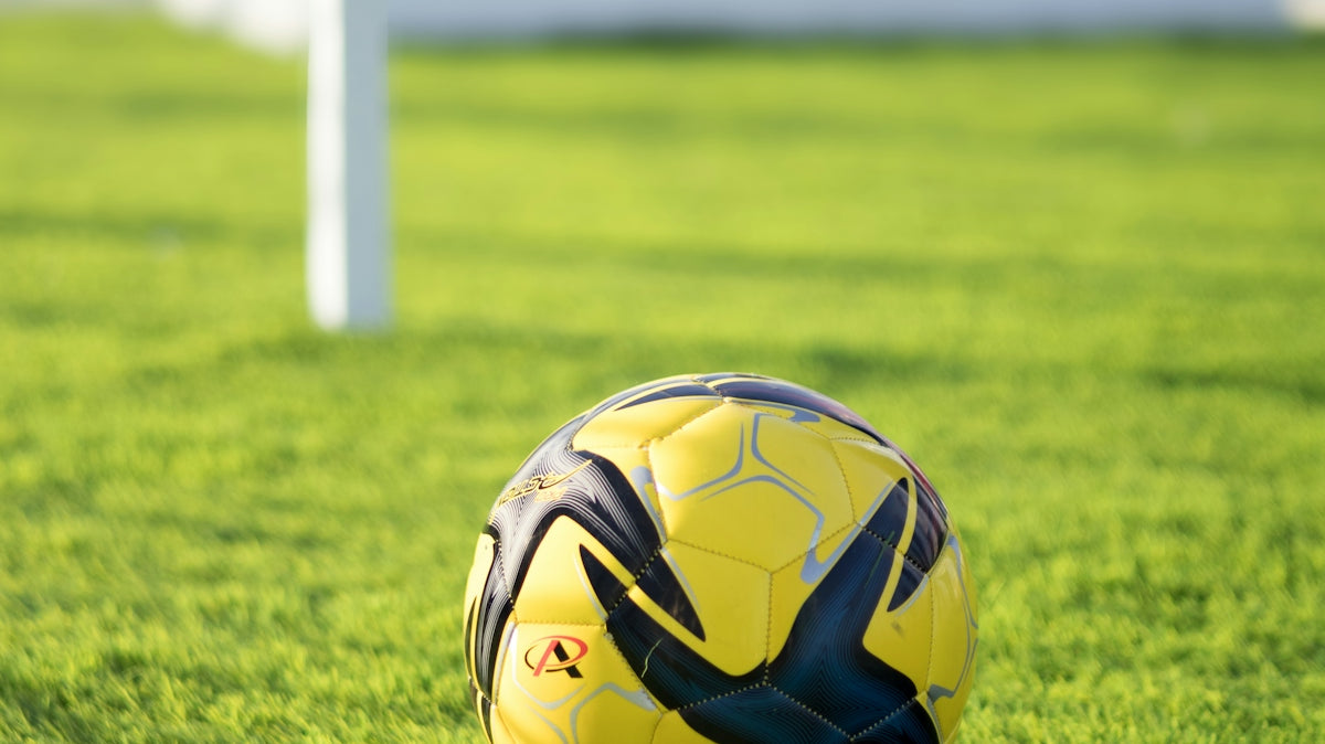 Soccer ball sits on the green field.