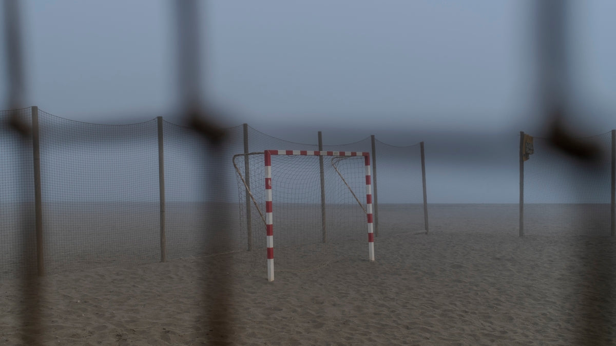 A handball goal on a foggy beach.