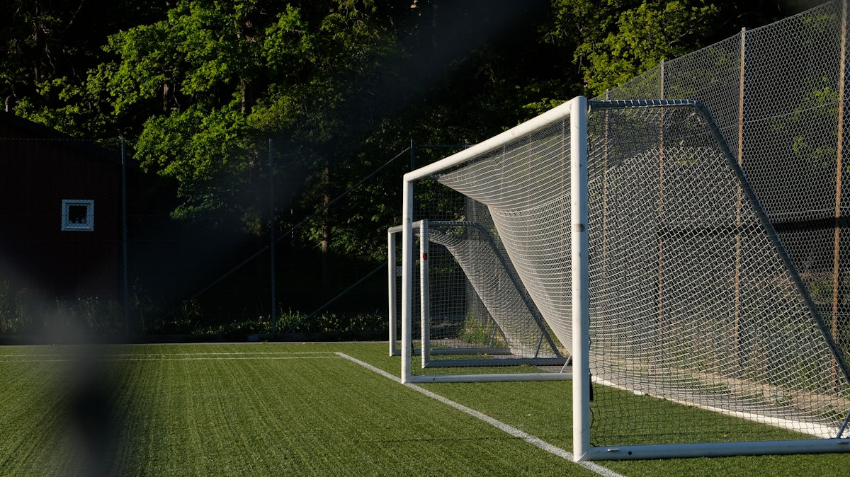Empty soccer goal on a green artificial turf field.