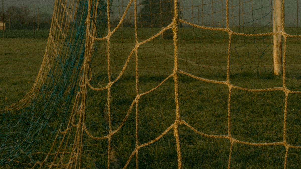 A soccer goal net on a green grassy field