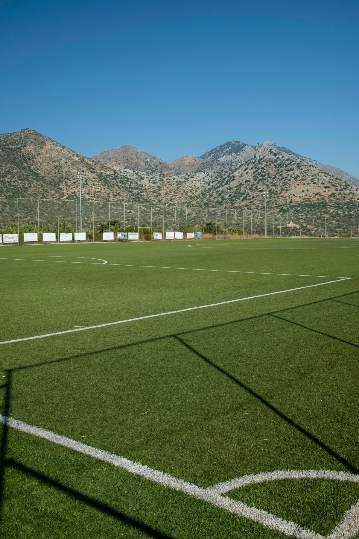a soccer field with mountains in the background