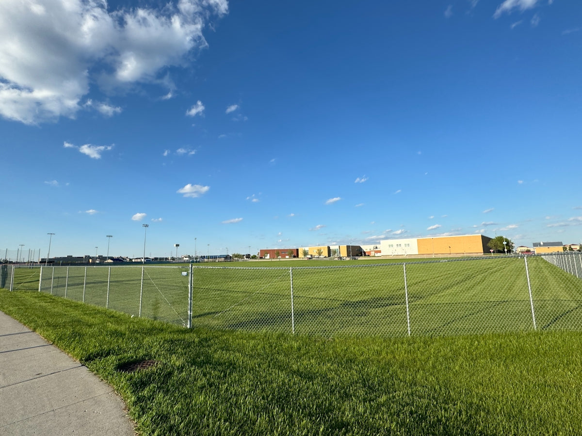 a grassy field with a building in the background