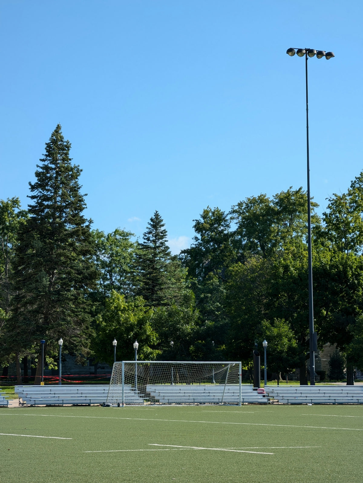 A soccer field with a goal and trees in the background