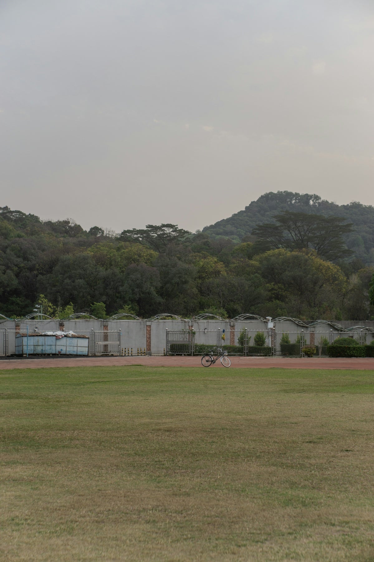 A bicycle on a track in front of green hills.