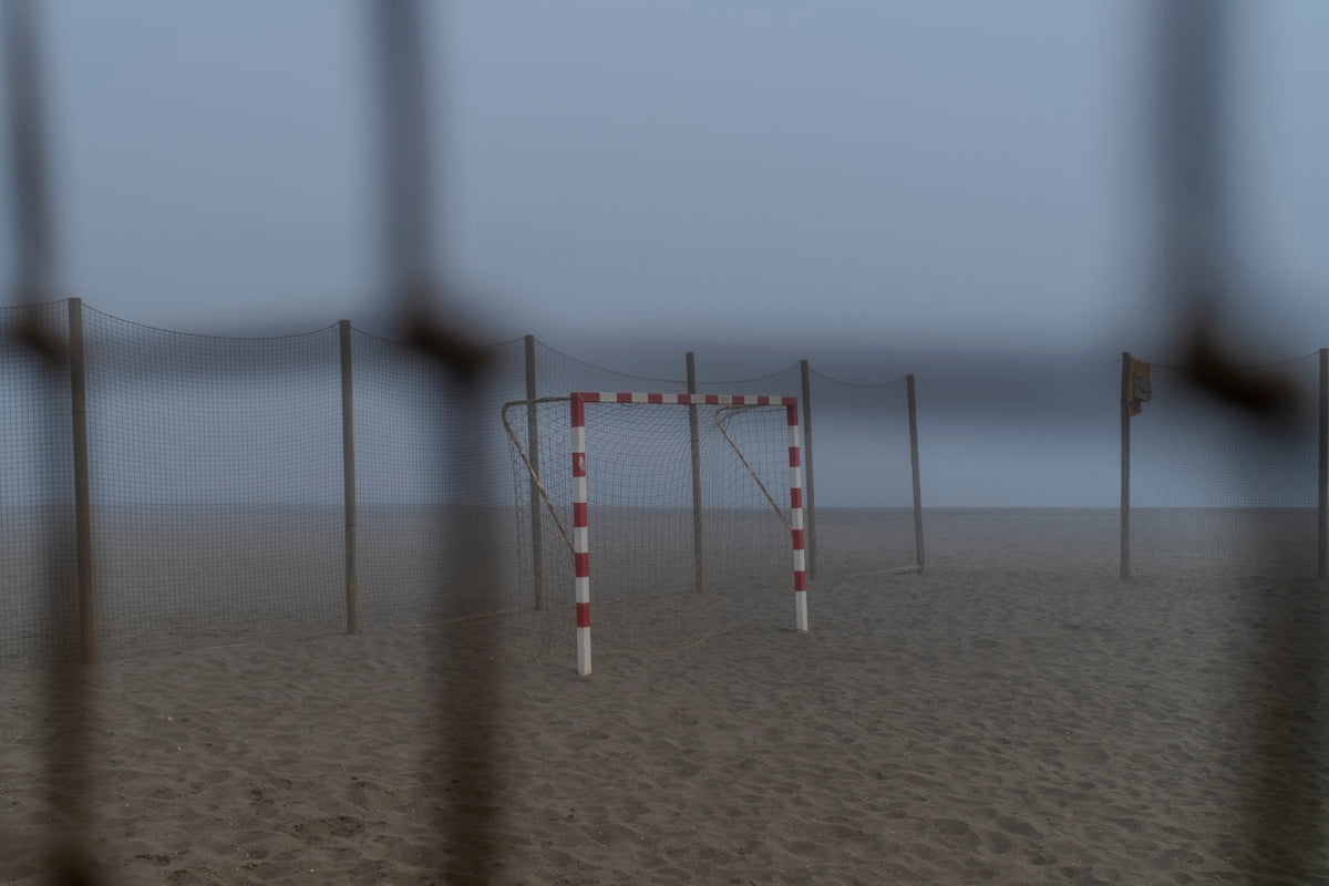 A handball goal on a foggy beach.