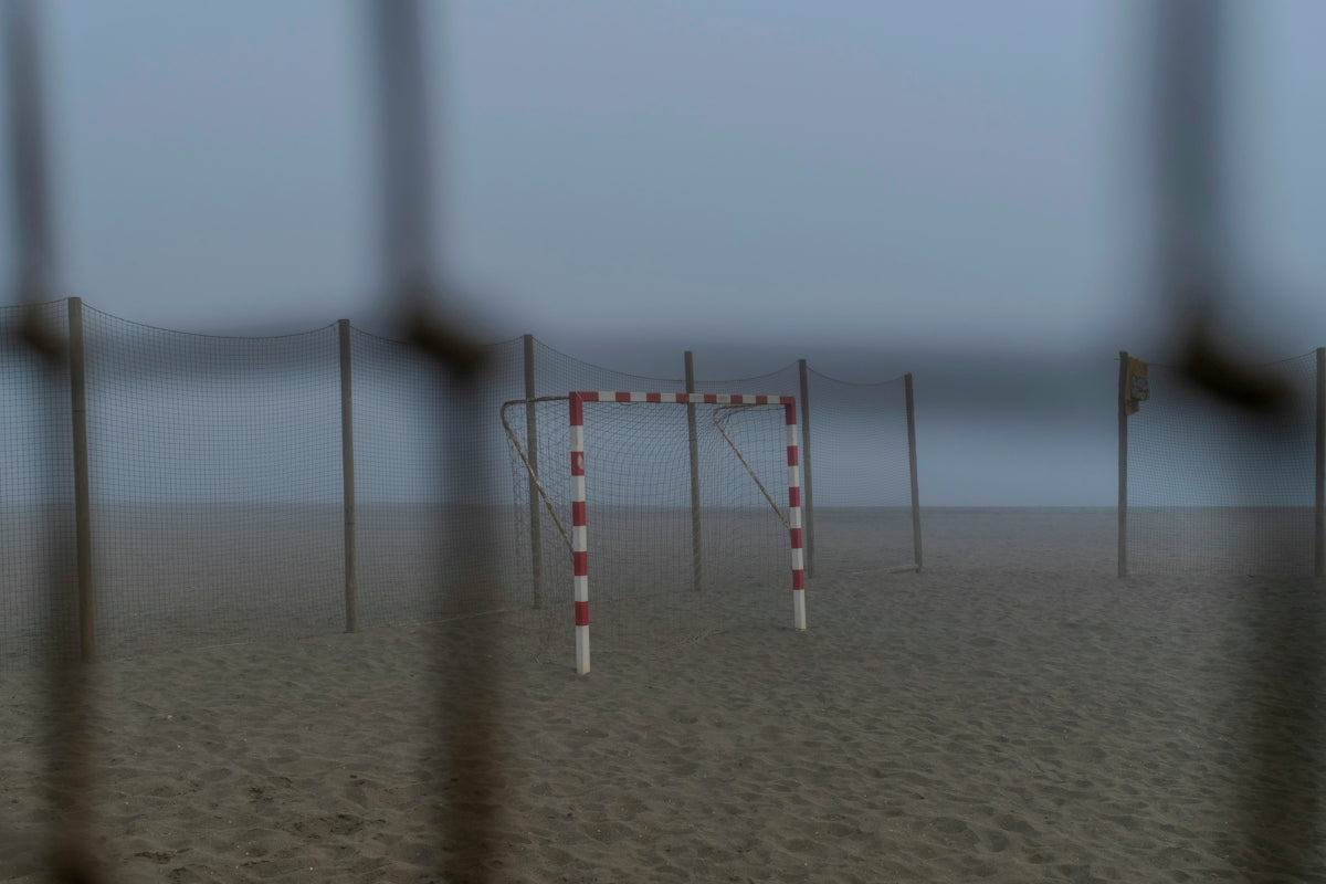 A handball goal on a foggy beach.