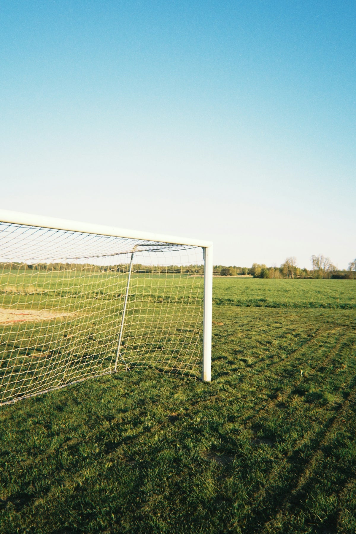 Soccer goal on a grassy field under a clear sky