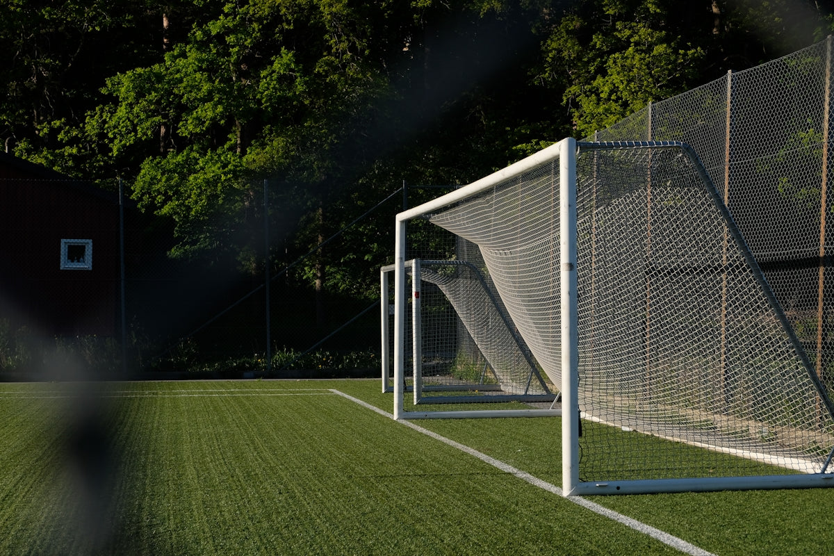 Empty soccer goal on a green artificial turf field.